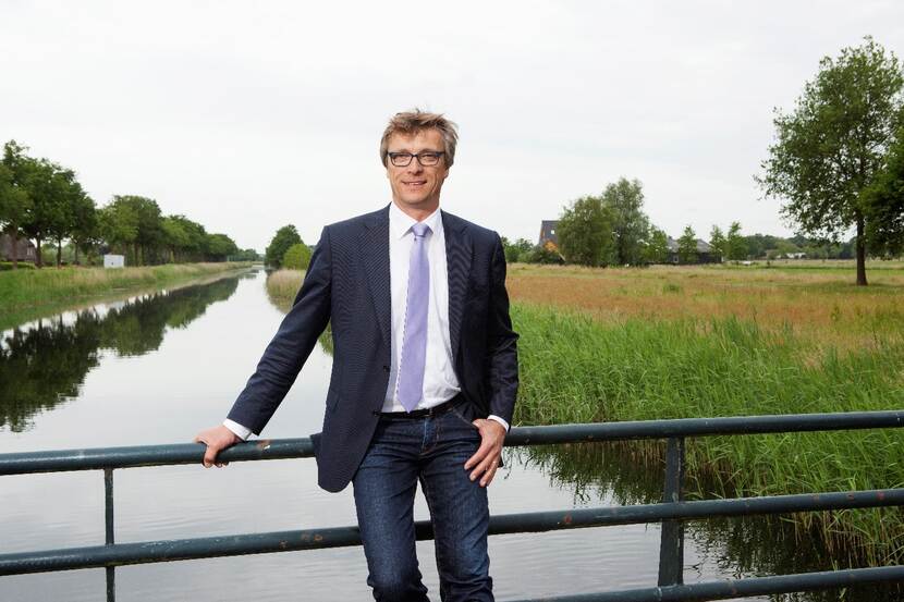Dirk-Siert-Schoonman poseert op een brug over een rivier of kanaal.