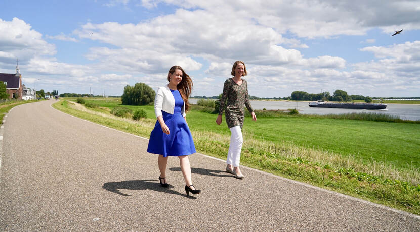 Suzanna van Nieuwkerk en Nicole Geurts van Kessel lopen over de dijk van het project Gorinchem-Waardenburg