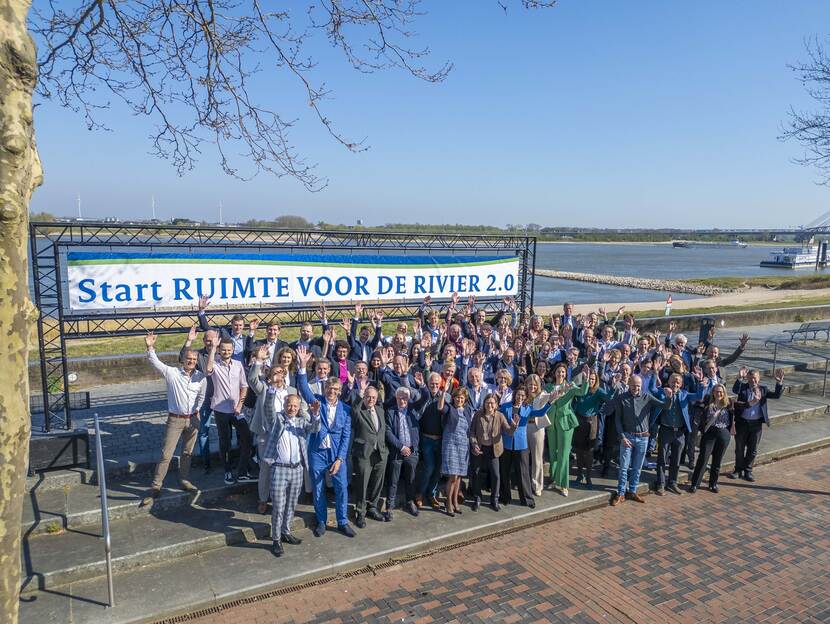 Groepsfoto van mensen met een banner met de tekst 'Start Ruimte voor de Rivier 2.0'
