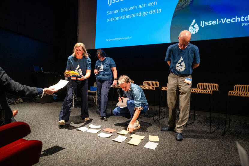 Mensen zijn bezig met een opdracht met blaadjes op de grond