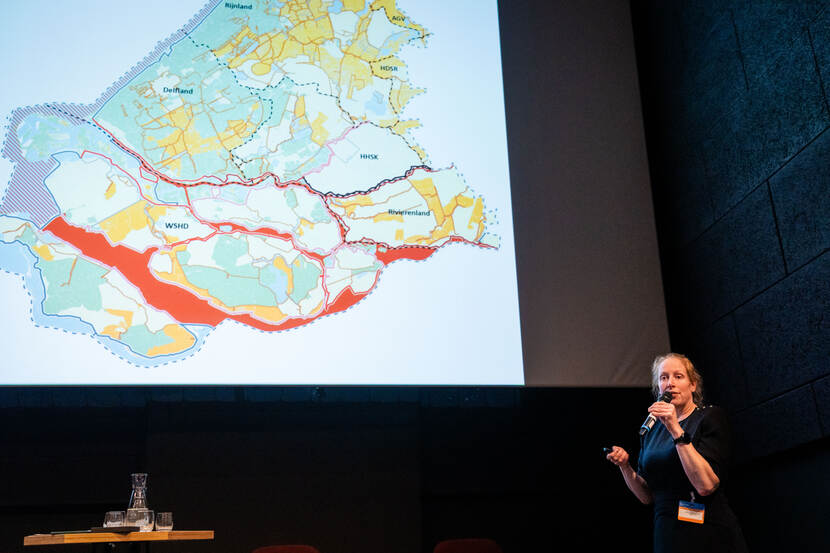 Vrouw geeft presentatie met kaart op de achtergrond