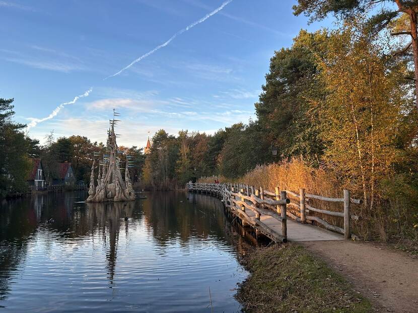 Een foto van de efteling waarop een kasteel in het water te zien is.