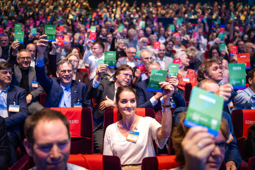Mensen in zaal stemmen met groene of rode bordjes om te laten weten of ze wel of niet een regenton in de tuin hebben