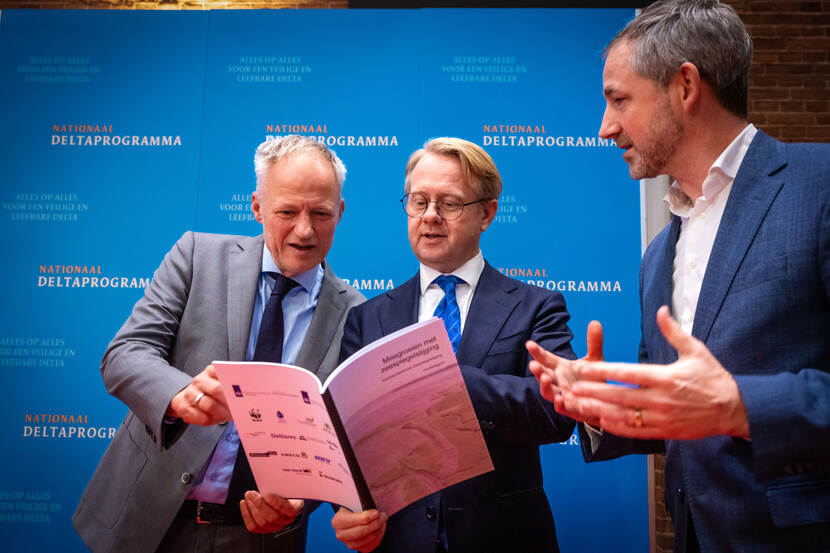Deltacommissaris Co Verdaas en minister Robert Tieman ontvangen het rapport van Alex Hekman.