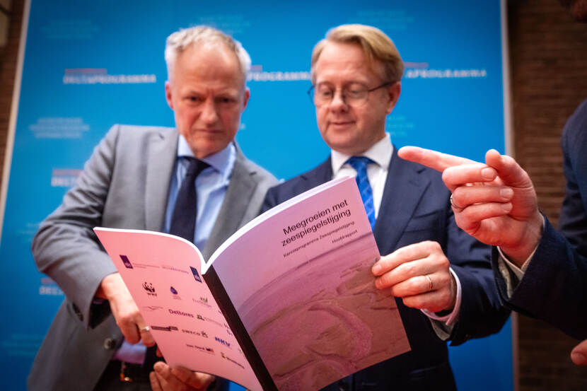 Deltacommissaris Co Verdaas en minister Robert Tieman bekijken nieuw rapport.