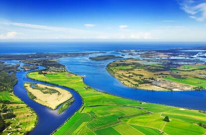 Landschap met veel groen land en blauw water